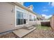 Cozy backyard featuring a small lawn, concrete steps, gravel, and privacy fencing at 5521 Ensenada St, Denver, CO 80249