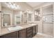 Bathroom with double sink vanity, tile backsplash, walk-in shower, and large mirror at 5521 Ensenada St, Denver, CO 80249