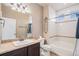 Bathroom featuring a single sink vanity and shower-tub combo at 5521 Ensenada St, Denver, CO 80249