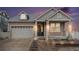 Charming home featuring stone accents, manicured landscaping, and an attached two-car garage at 5521 Ensenada St, Denver, CO 80249