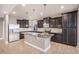 Well-equipped kitchen boasts an island, stainless steel appliances, dark cabinetry, and granite countertops at 5521 Ensenada St, Denver, CO 80249