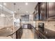 Spacious kitchen featuring dark cabinets, granite countertops, stainless steel appliances, and a mosaic backsplash at 5521 Ensenada St, Denver, CO 80249