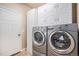 Bright laundry room featuring modern washer and dryer set and convenient storage cabinets at 5521 Ensenada St, Denver, CO 80249