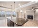 Open living room with a large island, recessed lighting, ceiling fans, and a cozy fireplace at 5521 Ensenada St, Denver, CO 80249