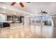 Open-concept living room featuring a kitchen island, tile flooring, and large windows for ample natural light at 5521 Ensenada St, Denver, CO 80249
