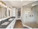 Modern bathroom featuring double vanity, large glass shower, and access to a spacious walk-in closet at 43 Falcon Hills Dr, Highlands Ranch, CO 80126