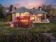 Beautiful brick home featuring a spacious red deck with lovely landscaping and a sunset sky at 43 Falcon Hills Dr, Highlands Ranch, CO 80126