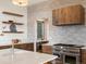 Modern kitchen featuring stone backsplash, stainless steel appliances, and custom cabinetry at 43 Falcon Hills Dr, Highlands Ranch, CO 80126