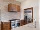 Gourmet kitchen features stainless steel appliances, stone backsplash, and custom wood range hood at 43 Falcon Hills Dr, Highlands Ranch, CO 80126