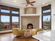 Bright living room with a brick fireplace and expansive windows with city views at 43 Falcon Hills Dr, Highlands Ranch, CO 80126