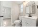Bathroom with vanity, toilet, arched mirror, and a window for natural light at 1269 N Revere St, Aurora, CO 80011