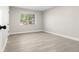 A bright, empty bedroom with light grey walls, a large window, and light-colored wood flooring at 1269 N Revere St, Aurora, CO 80011