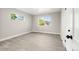 A bright bedroom with light grey walls, two windows, and light-colored wood flooring at 1269 N Revere St, Aurora, CO 80011