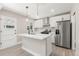 Bright modern kitchen with island, stainless steel appliances, white cabinets, and stylish pendant lights at 1269 N Revere St, Aurora, CO 80011
