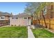 Lovely backyard with a small table set, a lush lawn, a detached garage, and a secure fence for privacy at 3259 Lowell Blvd, Denver, CO 80211