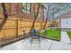 Inviting backyard features a patio with metal table set, grassy area, and wood fence offering privacy at 3259 Lowell Blvd, Denver, CO 80211
