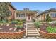 Charming brick home featuring a cozy front porch, brick garden bed, and inviting red front door at 3259 Lowell Blvd, Denver, CO 80211