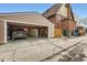 Detached garage with exposed wood, perfect for parking and projects, set against the brick home and clear blue sky at 3259 Lowell Blvd, Denver, CO 80211