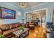 Stylish living room featuring hardwood floors, a leather sofa set, and an open layout leading to the dining area at 3259 Lowell Blvd, Denver, CO 80211