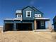 Two-story home exterior showing an attached two-car garage and a covered entryway in mid-construction at 39715 Gibson St, Elizabeth, CO 80107