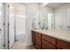 Bright bathroom featuring a large vanity with wood cabinets at 9723 Bennett Peak St, Littleton, CO 80125