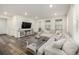 Bright living room with wooden floors, a spacious sectional couch, and large windows at 9723 Bennett Peak St, Littleton, CO 80125