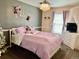 Bright and cheery bedroom with charming chandelier, pastel purple accents, and ample natural light at 19102 E Hampden Dr, Aurora, CO 80013