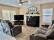 Cozy living room with a fireplace, plush seating, and soft natural light from the windows at 19102 E Hampden Dr, Aurora, CO 80013
