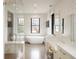 Bright bathroom with stand alone tub, large windows, white marble counters, and tiled shower at 3309 E 7Th Ave Pkwy, Denver, CO 80206