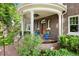 Charming covered porch with brick accents, classic columns, and beautiful landscaping around the front entrance at 3309 E 7Th Ave Pkwy, Denver, CO 80206