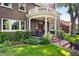 Charming covered porch with classic columns, brick accents, beautiful landscaping, and a well-manicured lawn at 3309 E 7Th Ave Pkwy, Denver, CO 80206