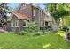 Beautiful brick home with lush landscaping, manicured lawn, and a charming balcony overlooking the yard at 3309 E 7Th Ave Pkwy, Denver, CO 80206