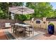 Inviting outdoor dining area features a table with seating for six, a large umbrella, and a decorative tile wall at 3309 E 7Th Ave Pkwy, Denver, CO 80206