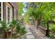 Charming walkway with stone pavers, leading through a lush, landscaped garden and wrought iron gate at 3309 E 7Th Ave Pkwy, Denver, CO 80206