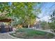 Lush backyard featuring a large grassy area, mature trees, and play equipment at 504 E Otero Ct, Littleton, CO 80122