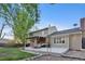 Expansive backyard with a large back deck, lush lawn, mature trees, and play equipment at 504 E Otero Ct, Littleton, CO 80122