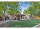 Large backyard featuring a back deck, lush lawn, mature trees, and play equipment at 504 E Otero Ct, Littleton, CO 80122