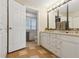Bright bathroom featuring a double vanity, tile flooring, and an open doorway with an adjoining toilet at 504 E Otero Ct, Littleton, CO 80122