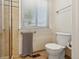 This bathroom features a tiled walk-in shower, toilet, towel rack, and a window with blinds at 504 E Otero Ct, Littleton, CO 80122