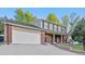 Attractive home boasts a blend of brick and siding, a covered porch, and a well-maintained lawn at 504 E Otero Ct, Littleton, CO 80122