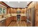 This inviting kitchen features wood cabinetry, stainless steel appliances, and warm, inviting lighting at 504 E Otero Ct, Littleton, CO 80122