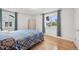 Bedroom with wood floors, large windows with drapes, and a bright interior at 3285 N Monaco Pkwy, Denver, CO 80207