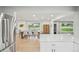 Open concept dining room with hardwood floors, large windows, and stainless steel refrigerator in view at 3285 N Monaco Pkwy, Denver, CO 80207
