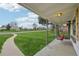 A view from the porch with a swing looking out to a green lawn and sidewalk at 3285 N Monaco Pkwy, Denver, CO 80207