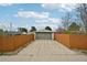 A driveway leading up to a gray two car garage with wooden fences on either side at 3285 N Monaco Pkwy, Denver, CO 80207