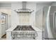 Modern kitchen features stainless steel hood, range, and refrigerator complemented by white cabinetry at 3285 N Monaco Pkwy, Denver, CO 80207