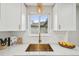 Bright kitchen features white cabinetry, subway tile backsplash, and modern gold fixtures at 3285 N Monaco Pkwy, Denver, CO 80207