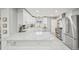 Bright kitchen featuring marble countertops, stainless steel appliances, an island, and modern white cabinetry at 3285 N Monaco Pkwy, Denver, CO 80207