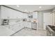 Bright kitchen features white cabinetry, subway tile backsplash, and modern gold fixtures at 3285 N Monaco Pkwy, Denver, CO 80207