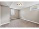 This is a carpeted basement room with white baseboard trim and bright, sunlit windows at 7833 Raritan St, Denver, CO 80221